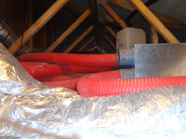 red semi-rigid ducting feeds air round the system